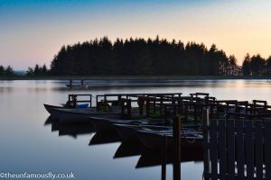 A still Morton fishery after sun set with two anglers being the only movement