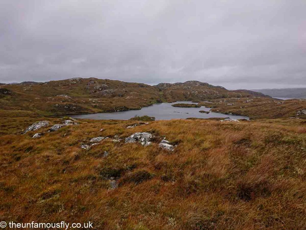 The lochan comes into view, still a grey and windy day