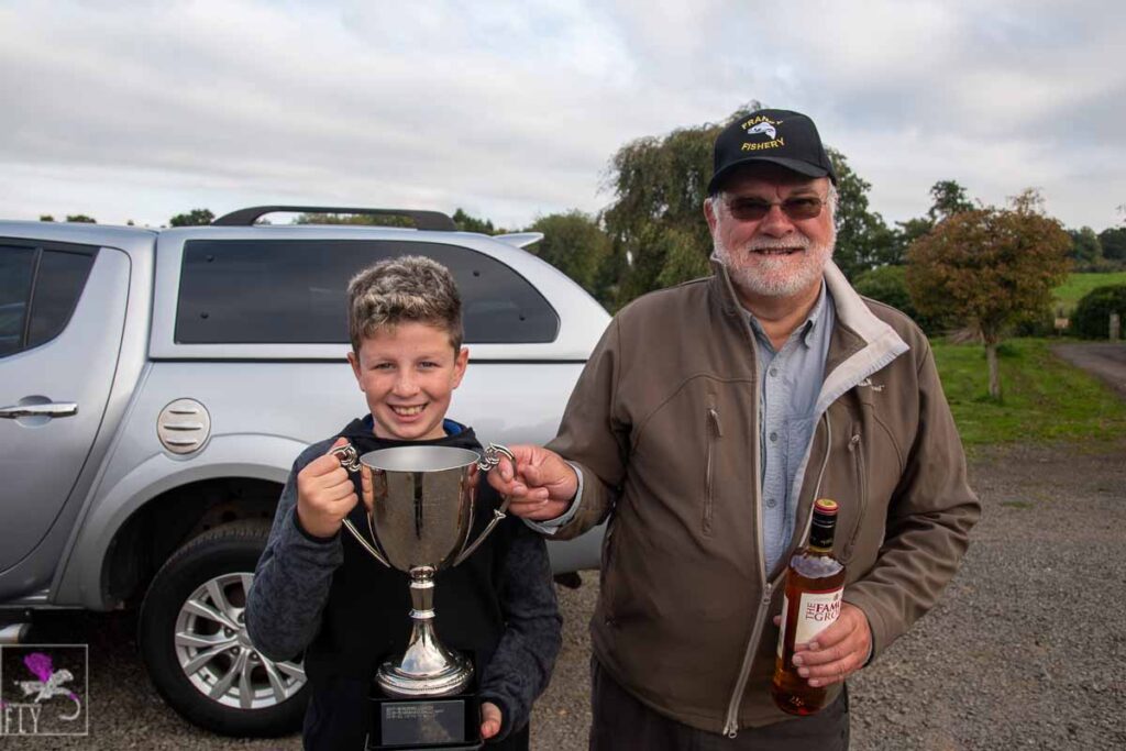 Bill collects the Trophy from Lex McCrindle's grandson